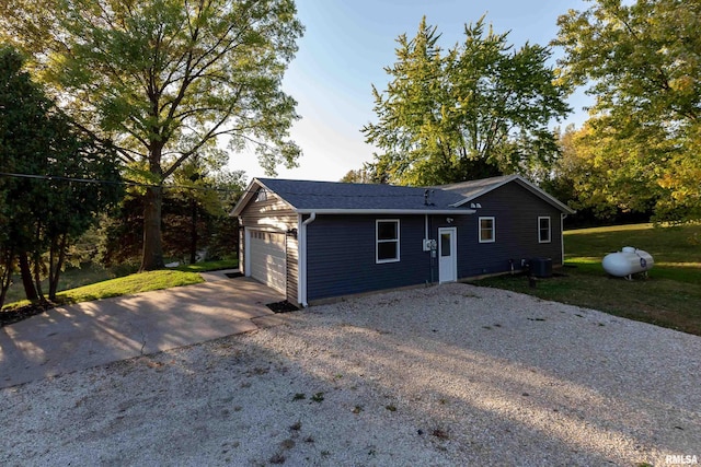 ranch-style house featuring central air condition unit and a garage