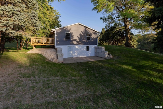 view of side of home featuring a wooden deck and a lawn