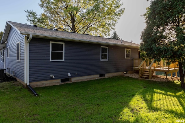 back of house featuring central AC, a lawn, and a wooden deck