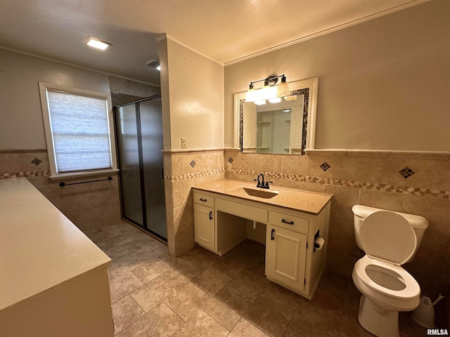 bathroom with an enclosed shower, vanity, tile walls, and toilet