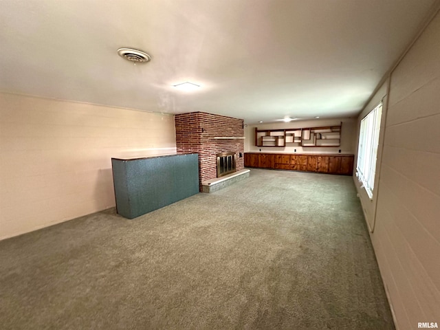 unfurnished living room with a fireplace and carpet