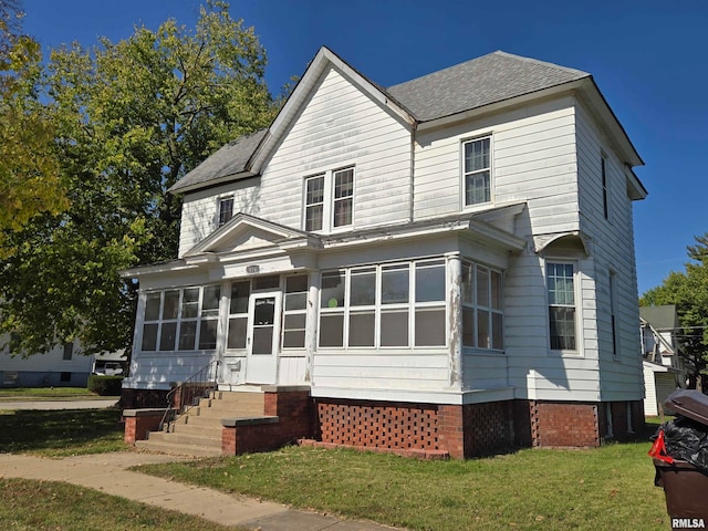 view of property featuring a sunroom and a front yard