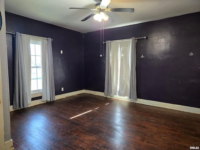 unfurnished room with ceiling fan and dark hardwood / wood-style flooring