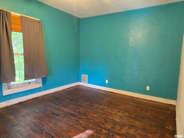 empty room featuring wood-type flooring and a healthy amount of sunlight