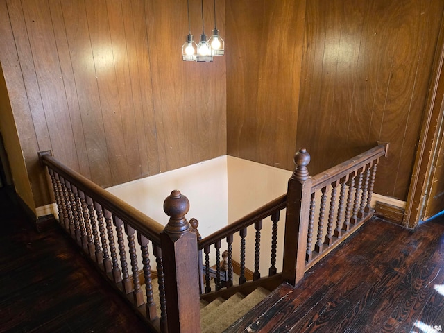 staircase featuring wood walls and hardwood / wood-style floors