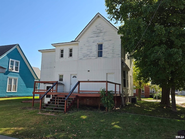 rear view of property with a deck, a yard, and central AC