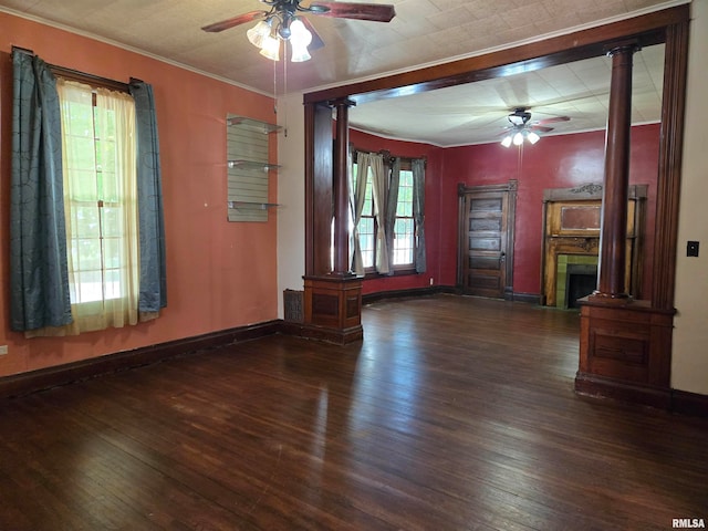 unfurnished living room with ceiling fan, dark hardwood / wood-style floors, decorative columns, and crown molding