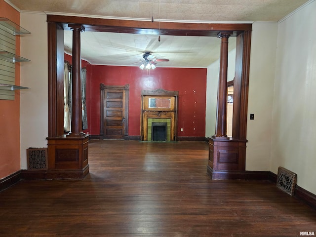 unfurnished living room with ornamental molding, decorative columns, ceiling fan, and dark hardwood / wood-style floors