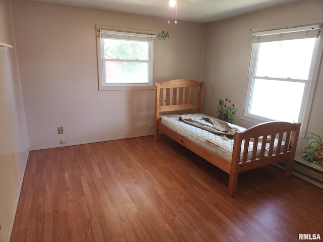 unfurnished bedroom featuring hardwood / wood-style floors and multiple windows