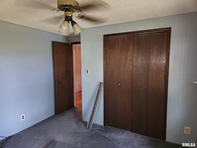 unfurnished bedroom with ceiling fan, a textured ceiling, a closet, and carpet flooring