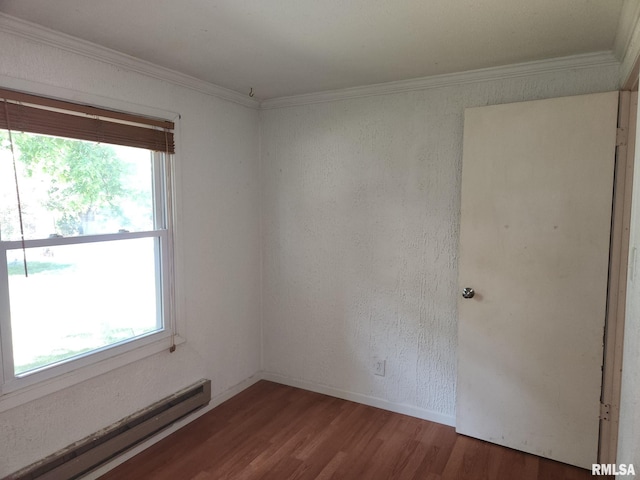 unfurnished room featuring wood-type flooring, baseboard heating, and ornamental molding