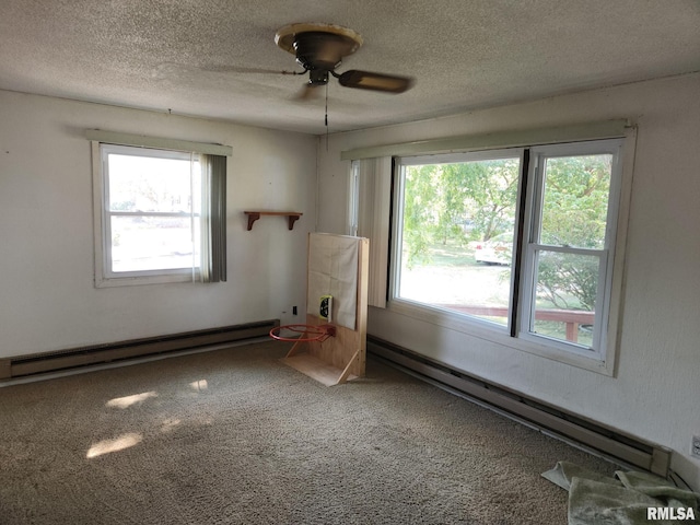 carpeted empty room featuring ceiling fan, a textured ceiling, and a baseboard radiator