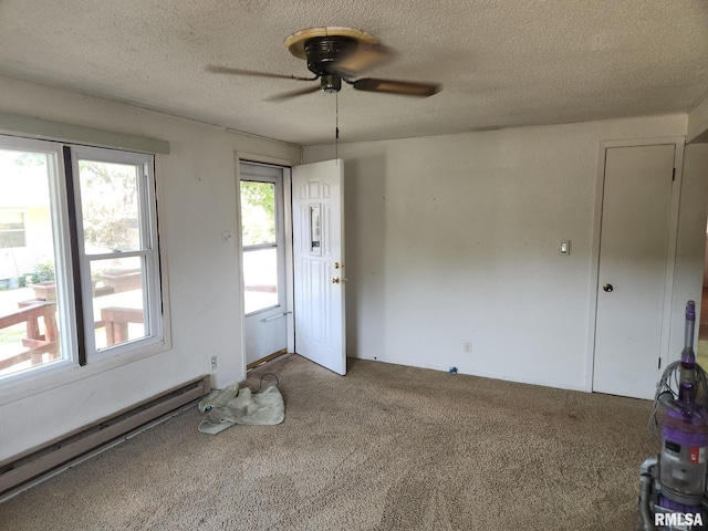 carpeted empty room featuring ceiling fan, a baseboard heating unit, and a textured ceiling