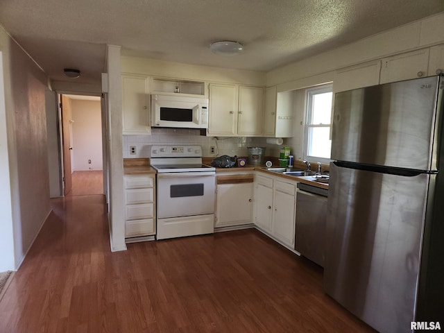136 W 5th Ave, Woodhull, IL 61490 - kitchen featuring stainless steel appliances, a sink, dark wood-type flooring, decorative backsplash, and a textured ceiling