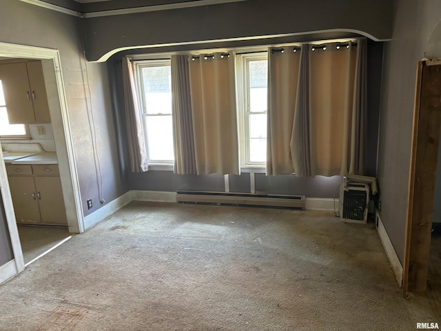 unfurnished room with plenty of natural light, baseboard heating, and light carpet