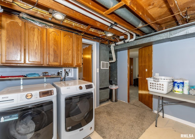 clothes washing area with independent washer and dryer and cabinets