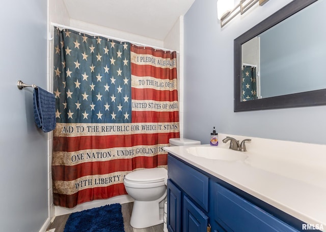 bathroom with walk in shower, vanity, and toilet