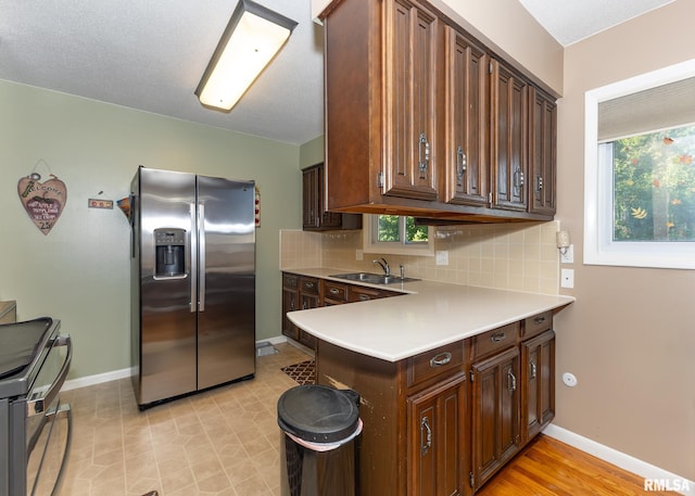 kitchen featuring appliances with stainless steel finishes, sink, decorative backsplash, and a wealth of natural light