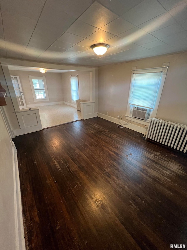 spare room with radiator, cooling unit, and dark wood-type flooring