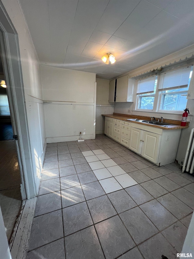 kitchen with radiator heating unit and light tile patterned floors