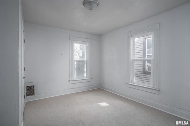 718 17th St, Rock Island, IL 61201 - empty room featuring carpet floors, a healthy amount of sunlight, visible vents, and baseboards