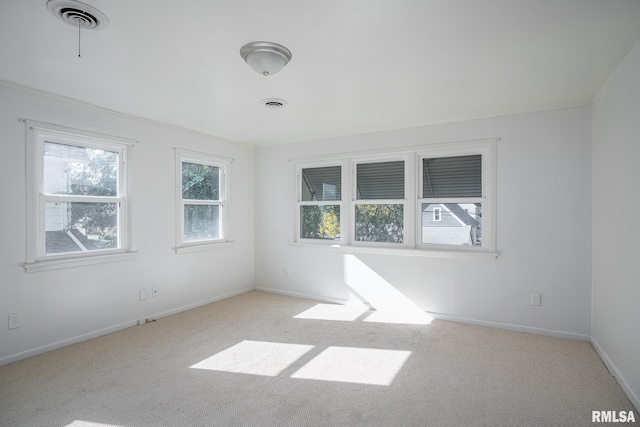 unfurnished room featuring light colored carpet, visible vents, and baseboards