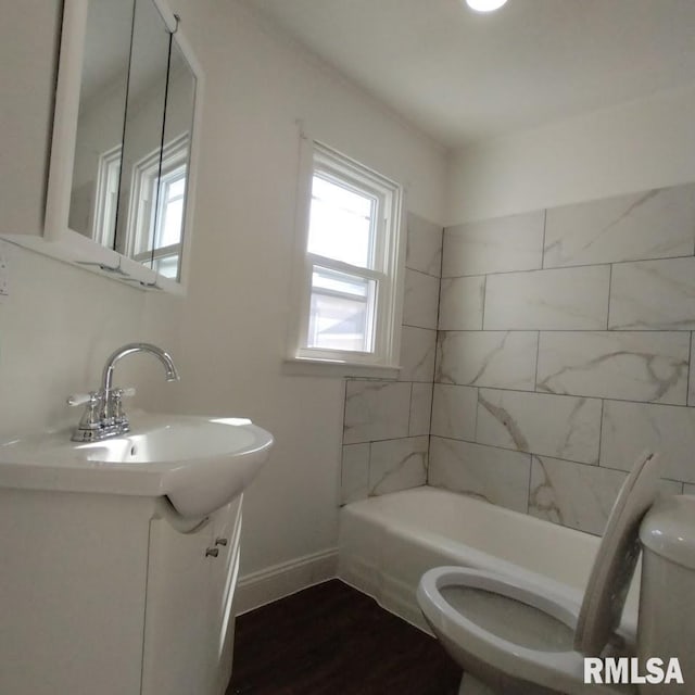 bathroom featuring toilet, baseboards, shower / bathing tub combination, and vanity