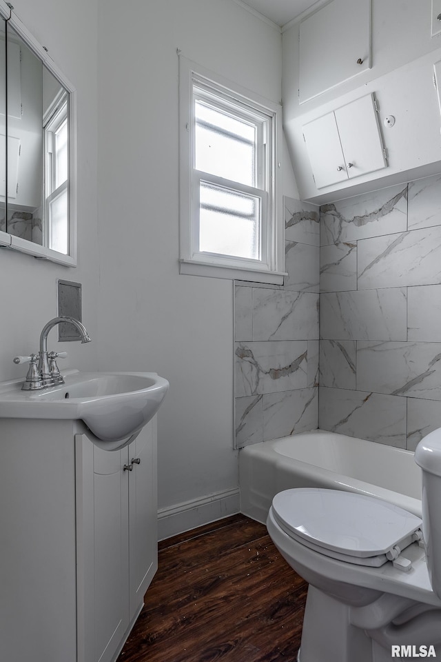 full bath with toilet, baseboards, wood finished floors, and vanity