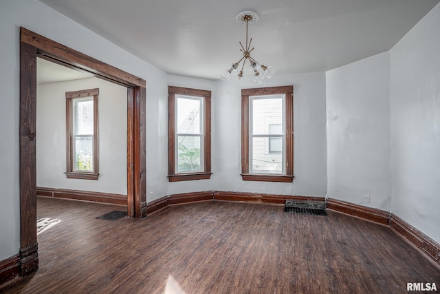 718 17th St, Rock Island, IL 61201 - empty room with dark wood-type flooring, visible vents, baseboards, and an inviting chandelier