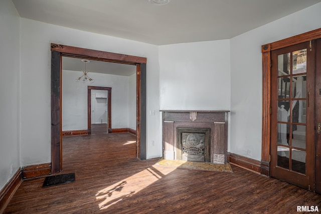 unfurnished living room with dark wood-style floors, visible vents, and baseboards