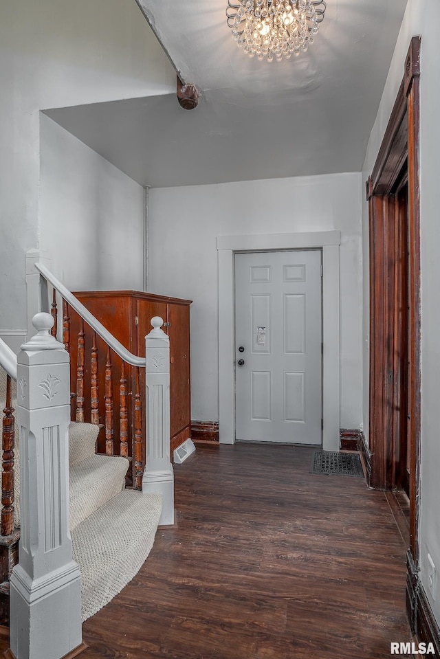 entryway featuring an inviting chandelier, stairs, baseboards, and dark wood-style flooring