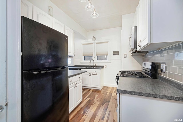 kitchen featuring sink, backsplash, white cabinetry, stainless steel appliances, and light hardwood / wood-style floors