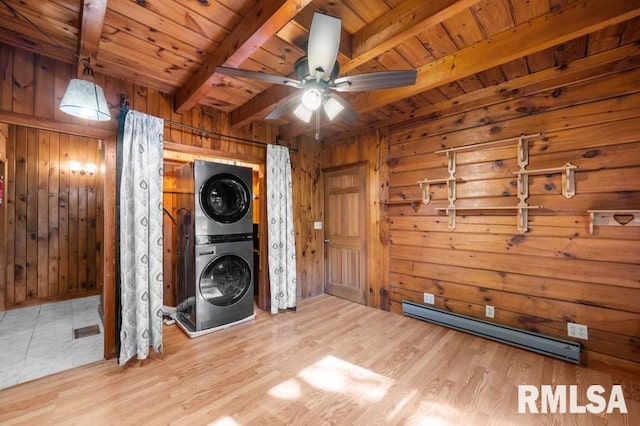 laundry room featuring a baseboard radiator, wooden ceiling, light hardwood / wood-style flooring, wood walls, and stacked washer and dryer