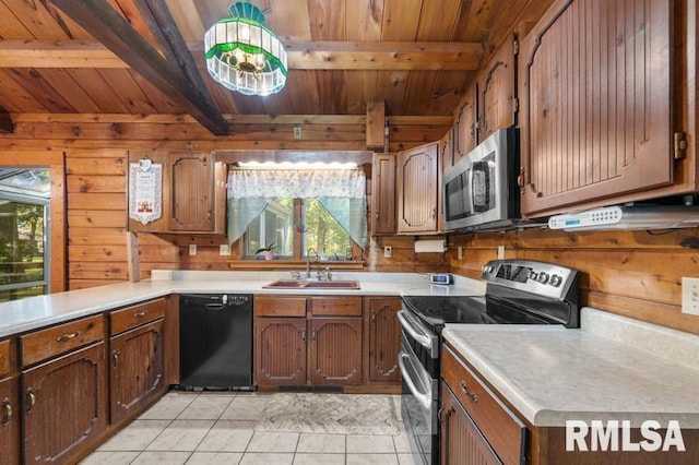 kitchen featuring appliances with stainless steel finishes, wood walls, plenty of natural light, and light tile patterned floors