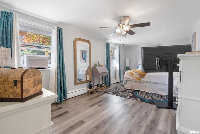 bedroom with multiple windows, a baseboard radiator, and light hardwood / wood-style floors