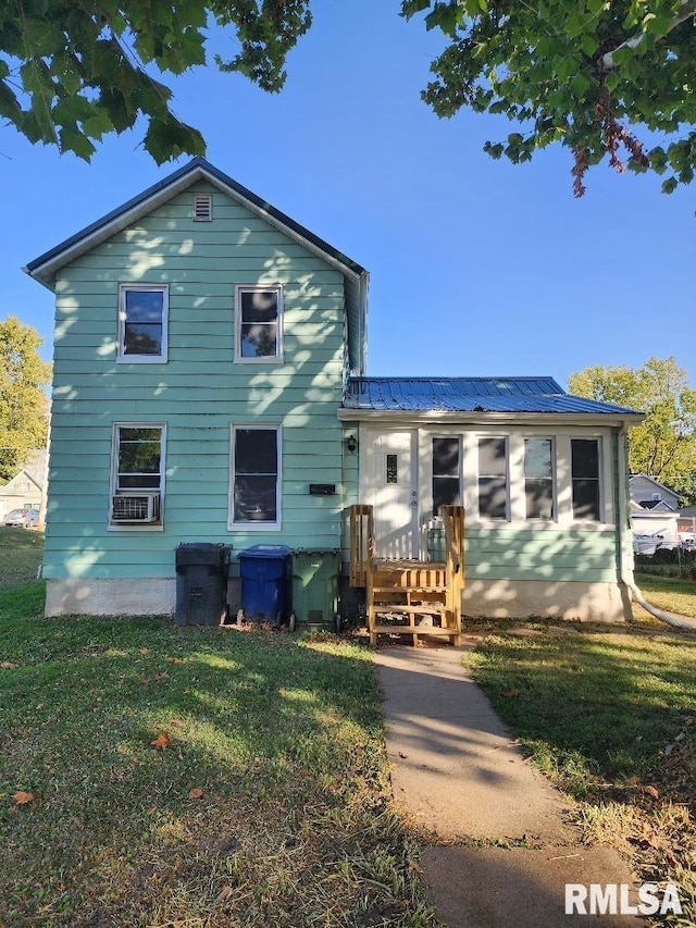 view of front of house with cooling unit and a front lawn