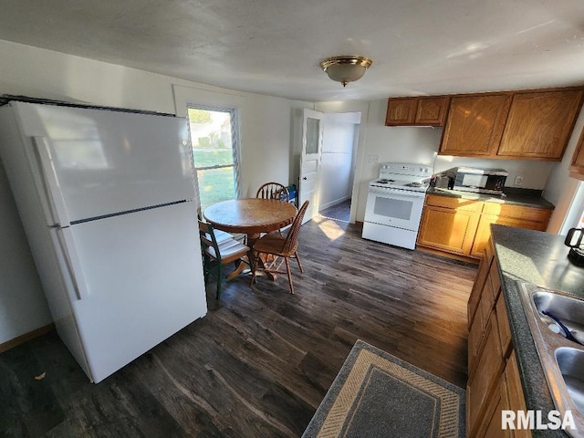 kitchen with white appliances, dark hardwood / wood-style flooring, and sink