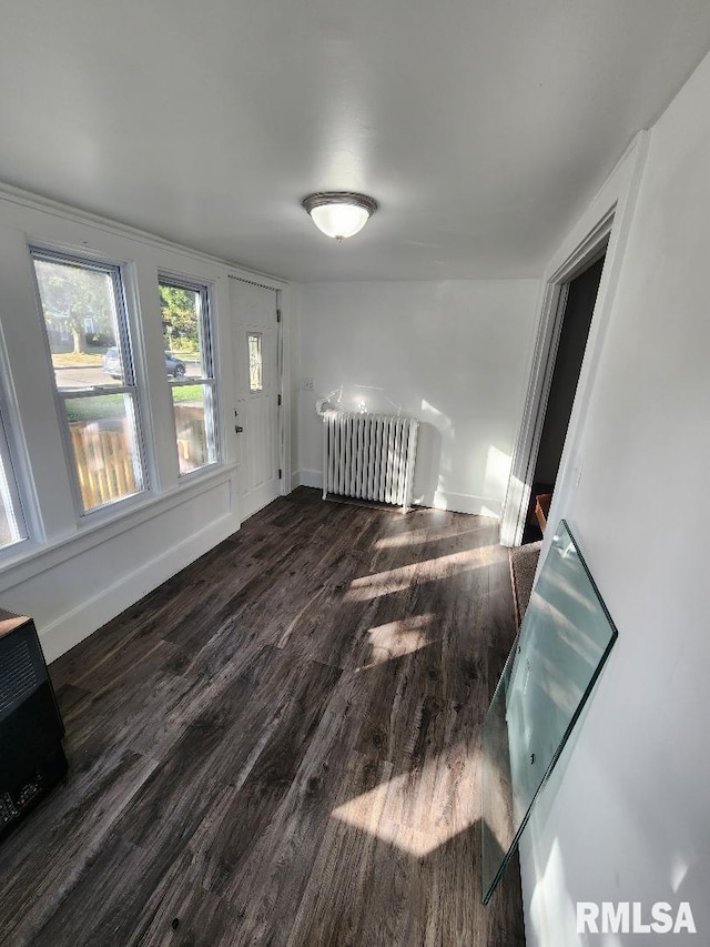 empty room with radiator and dark hardwood / wood-style floors