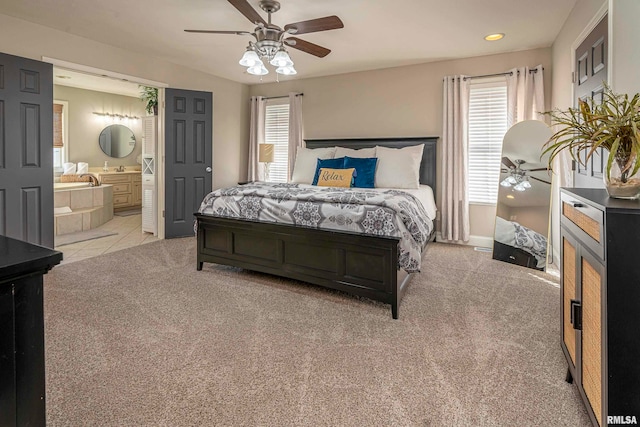 carpeted bedroom with ceiling fan and connected bathroom