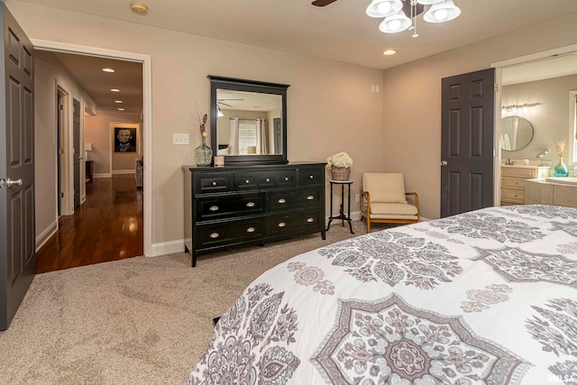 bedroom featuring connected bathroom, dark colored carpet, and ceiling fan