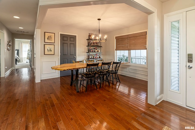 dining area featuring dark wood-type flooring and a chandelier