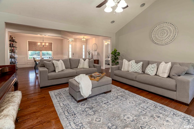 living room featuring dark wood-type flooring, vaulted ceiling, and ceiling fan with notable chandelier