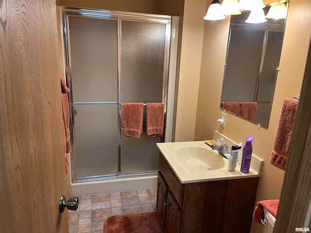 bathroom with a shower with door and vanity