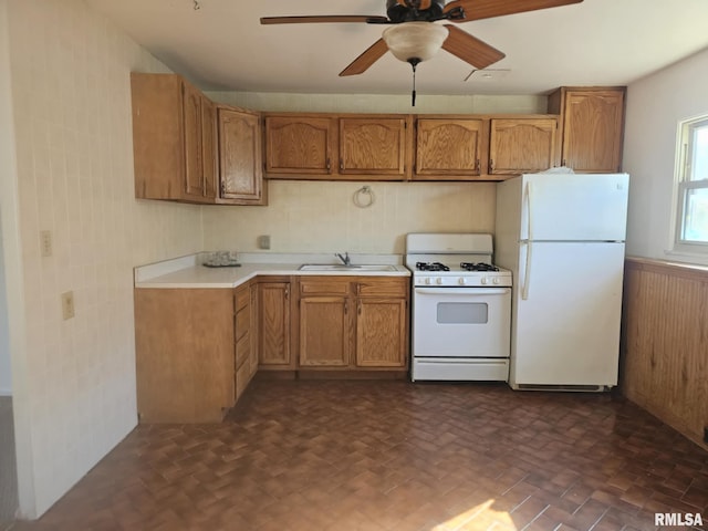 kitchen featuring white appliances, ceiling fan, tile walls, and sink