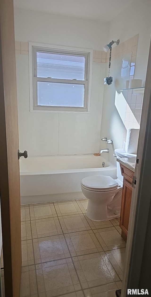 full bathroom featuring vanity, tiled shower / bath combo, and toilet