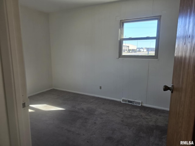 spare room with dark carpet