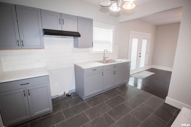 kitchen with french doors, tasteful backsplash, sink, dark hardwood / wood-style flooring, and gray cabinets