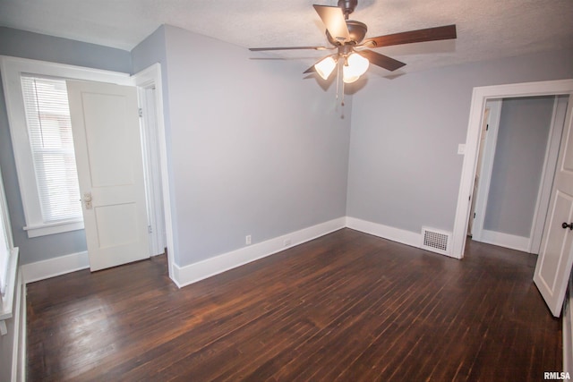 interior space featuring ceiling fan, a wealth of natural light, a textured ceiling, and dark hardwood / wood-style flooring