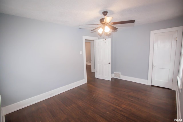 unfurnished room featuring ceiling fan, dark hardwood / wood-style floors, and a textured ceiling