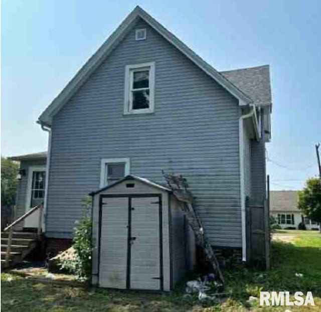 rear view of house with a storage shed